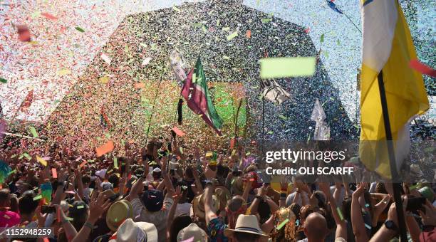 Revellers cheer as Australian singer Kylie performs at the Glastonbury Festival of Music and Performing Arts on Worthy Farm near the village of...
