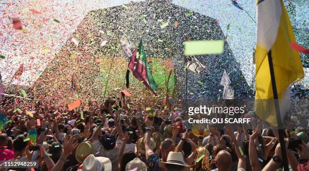 Revellers cheer as Australian singer Kylie performs at the Glastonbury Festival of Music and Performing Arts on Worthy Farm near the village of...