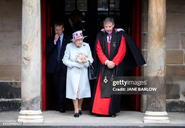Britain's Queen Elizabeth II talks with Reverend Neil Gardner as she attends the Sunday Church service at Canongate Kirk in Edinburgh on June 30,...