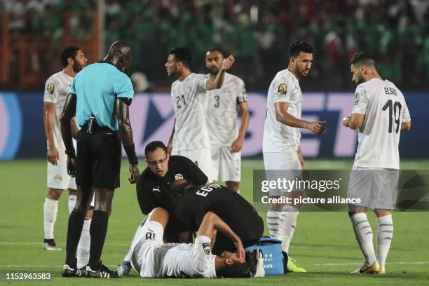 June 2019, Egypt, Cairo: Egypt's Ahmed Hassan Mahgoub receives medical attention after sustaining an injury during the 2019 Africa Cup of Nations...