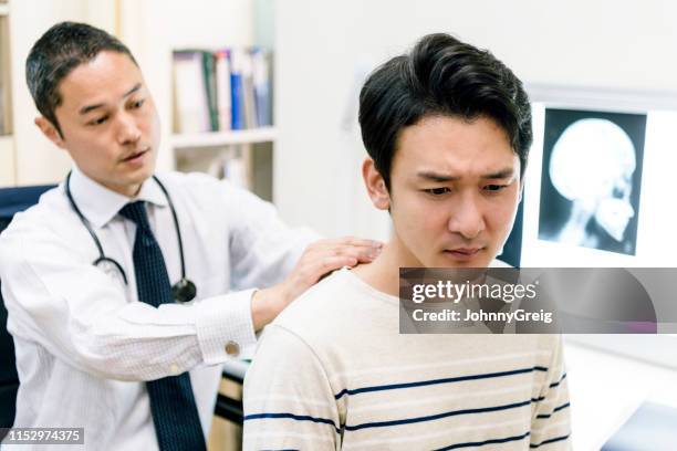 doctor examinando la espalda del paciente para comprobar si hay lesiones - escapula fotografías e imágenes de stock