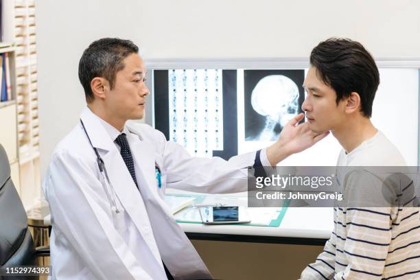 doctor examining patient's jaw in hospital - human jaw bone stock pictures, royalty-free photos & images