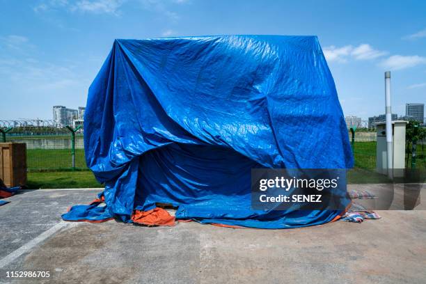 cargo covered with tarpaulin - tarpaulin stockfoto's en -beelden