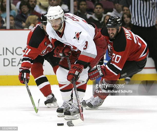 Matt Cullen of the Carolina Hurricanes moves past John Madden and Jay Pandolfo of the New Jersey Devils during the second period of game three in the...