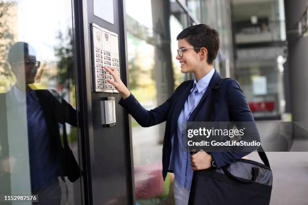 imprenditrice che entra in un edificio - citofono foto e immagini stock