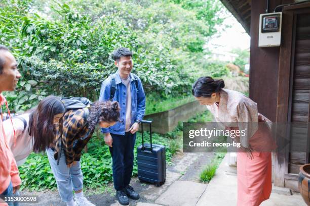 female owner of japanese inn welcoming tourists from oversees - bowing stock pictures, royalty-free photos & images