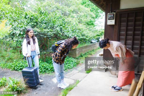 owner of japanese inn greeting female tourists from oversees - bowing stock pictures, royalty-free photos & images