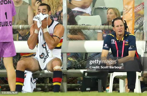 Taylor Walker of the Crows sits on the bench next to Don Pyke ,coach of the Crows during the round 11 AFL match between the Melbourne Demons and the...