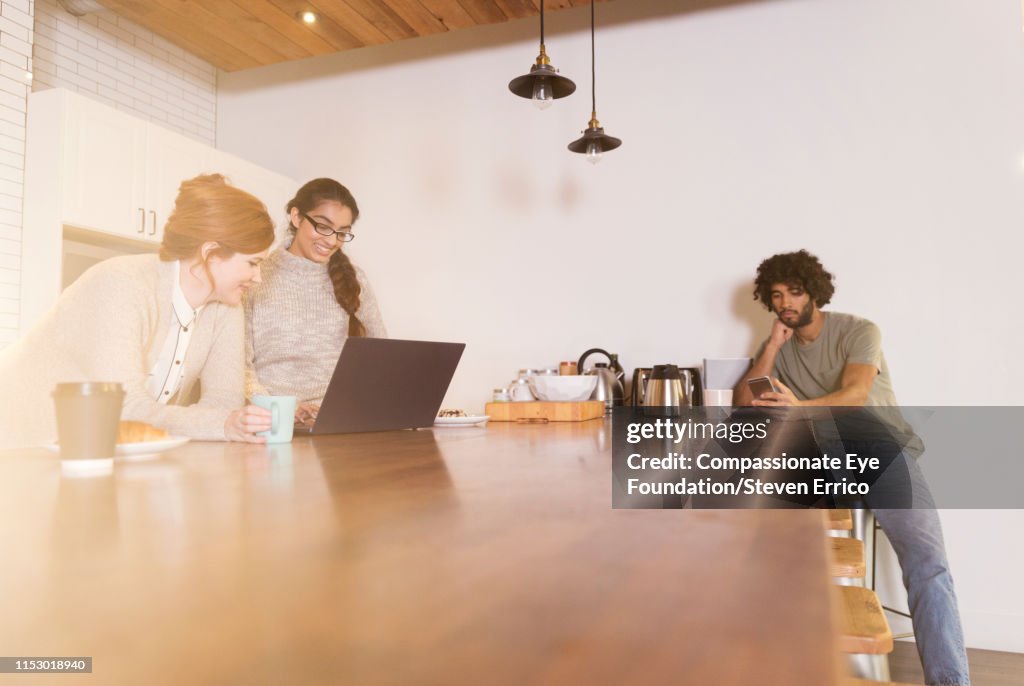 Creative business people having informal meeting in office kitchen