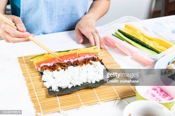 woman prepares sushi rolls, hands closeup - nori stock pictures, royalty-free photos & images