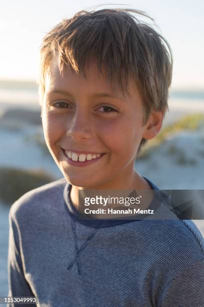 portrait of a smiling boy aged 11-12 years old on the beach - 12 13 years ストックフォトと画像