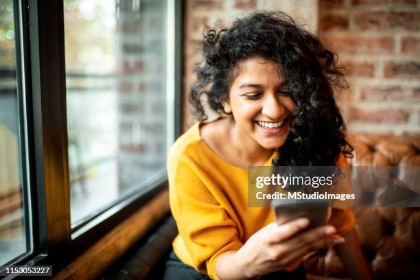 smiling indian woman using mobile phone. - indian woman phone stock pictures, royalty-free photos & images