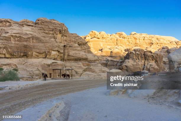 PETRA, JORDAN - OCTOBER 13, 2018: Tourists in narrow passage of rocks of Petra canyon in Jordan, UNESCO World Heritage Site since 1985. Way through Siq gorge to stone city Petra