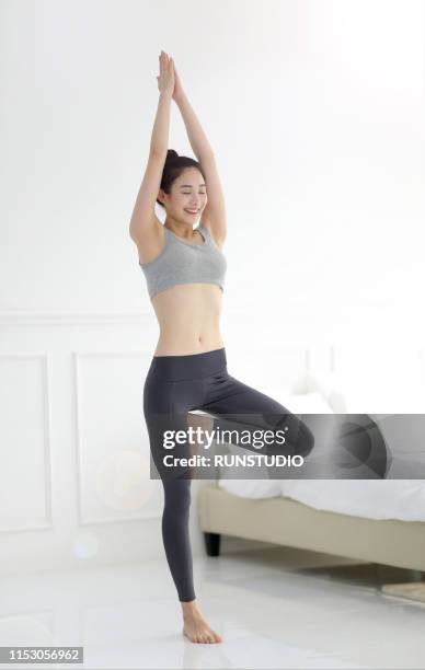 woman doing yoga in bedroom - レギンス　 ストックフォトと画像