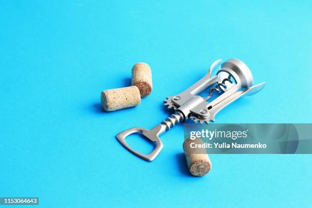 metal corkscrew for wine and cork on a blue background. - iron wine stock pictures, royalty-free photos & images