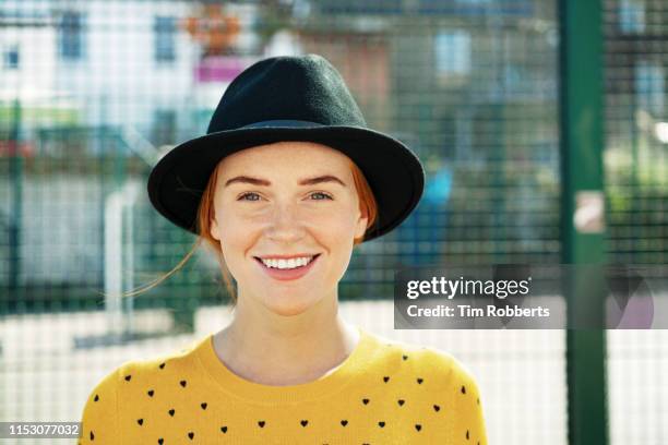 happy young woman smiling at camera. - yellow hat stock pictures, royalty-free photos & images