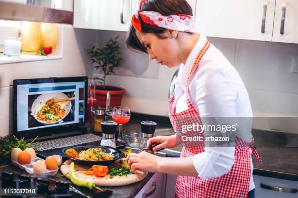 mujer haciendo comida con tutorial - tutorial fotografías e imágenes de stock