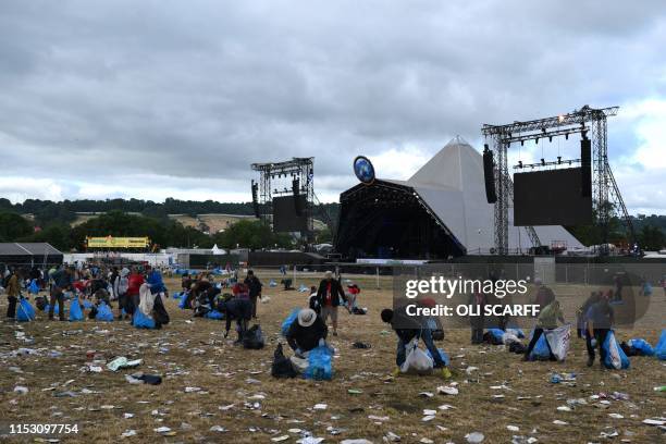 Litter pickers remove rubbish at Glastonbury Festival of Music and Performing Arts on Worthy Farm near the village of Pilton in Somerset, South West...