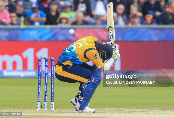 Sri Lanka's captain Dimuth Karunaratne ducks to avoid a bouncer during the 2019 Cricket World Cup group stage match between Sri Lanka and West Indies...