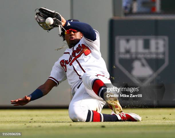 Centerfielder Ronald Acuna Jr. #13 of the Atlanta Braves slides but is unable to catch a line drive hit for a double by second baseman Brandon Dixon...