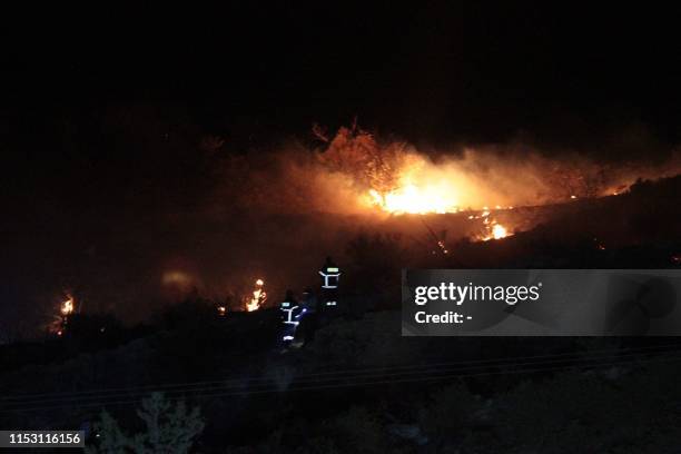 Fire is seen on a hillside where officials said was caused by a suspected Russian missile that exploded overnight on July 1 in the northern part of...