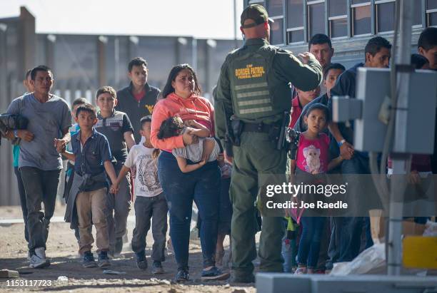 Migrants are loaded onto a bus by U.S. Border Patrol agents after being detained when they crossed into the United States from Mexico on June 01,...