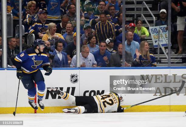 David Backes of the Boston Bruins is checked into the boards by Sammy Blais of the St. Louis Blues during the first period in Game Three of the 2019...