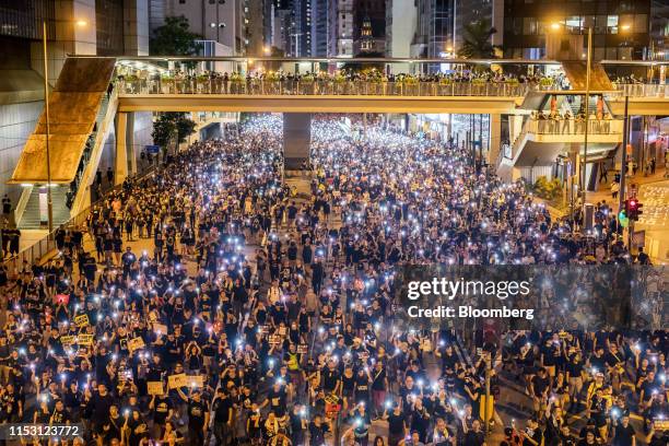 Demonstrators hold placards and illuminated smartphones during an annual pro-democracy rally in Hong Kong, China, on Monday, July 1, 2019. Tension...