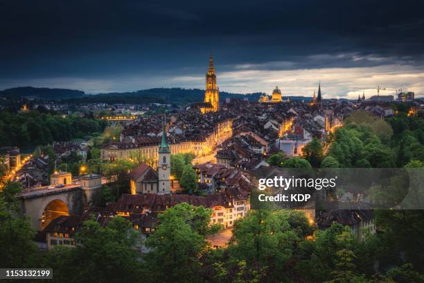 sunset scenery in bern and city illuminating lights, bern, switzerland - bern stadt stock-fotos und bilder