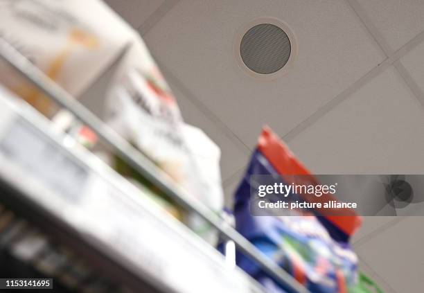 June 2019, North Rhine-Westphalia, Cologne: Loudspeakers are embedded in the ceiling of a supermarket of the retail chain Rewe. Background music is...