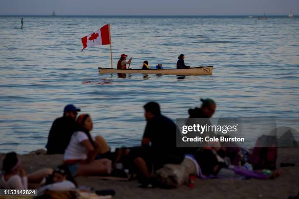 People canoe in Lake Ontario as beachgoers enjoy the last light of the day during Canada Day, on July 1, 2019 in Toronto, Canada. Canada Day...
