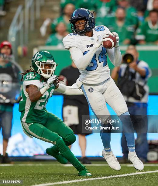 Llevi Noel of the Toronto Argonauts makes a catch in front of Loucheiz Purifoy of the Saskatchewan Roughriders in the game between the Toronto...