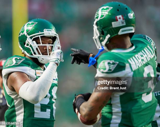 Loucheiz Purifoy and Nick Marshall of the Saskatchewan Roughriders celebrate after Marshalls interception in the game between the Toronto Argonauts...