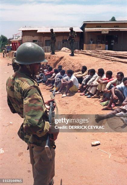 Rwandan government soldiers guard arrested civilians 07 October 1990 in Kigali following clashes between rebels and government forces. In October...