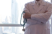 Medical doctor or physician in white gown uniform with stethoscope in hospital or clinic. Healthcare urban concept.