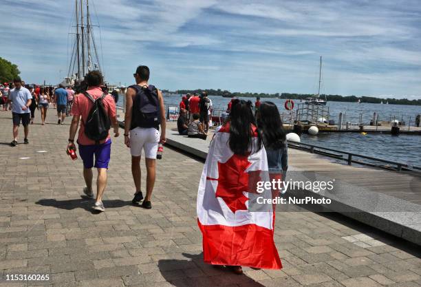 Woman draped in a Canadian flag walks along the path near Lake Ontario during the 152nd Canada Day celebration in Toronto, Ontario, Canada on July...