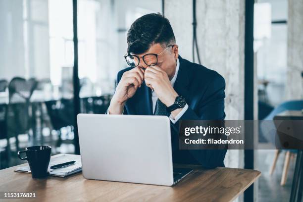 tired businessman - rubbing eyes stock pictures, royalty-free photos & images