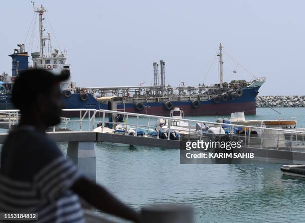 Man watches on July 2, 2019 the ships movement in the port of Fujairah in the east of the United Arab Emirates , where recent tensions spiraling...