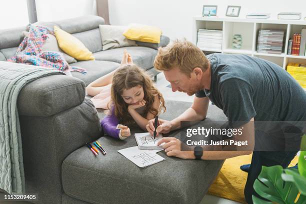 daddy and daughter - playing noughts and crosses - kind gips stock-fotos und bilder