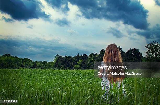 young girl in field with storm clouds - murfreesboro tennessee stock pictures, royalty-free photos & images