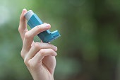 Asthma medecine inhaler holded by a man
