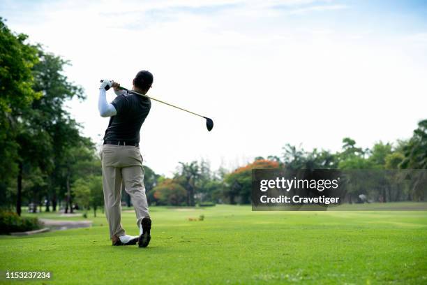 golfer hitting golf shot with club on course while on summer vacation. - golf tee foto e immagini stock