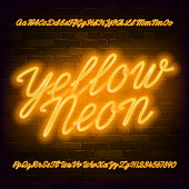 Yellow Neon script alphabet font. Neon color lowercase and uppercase bright letters and numbers.