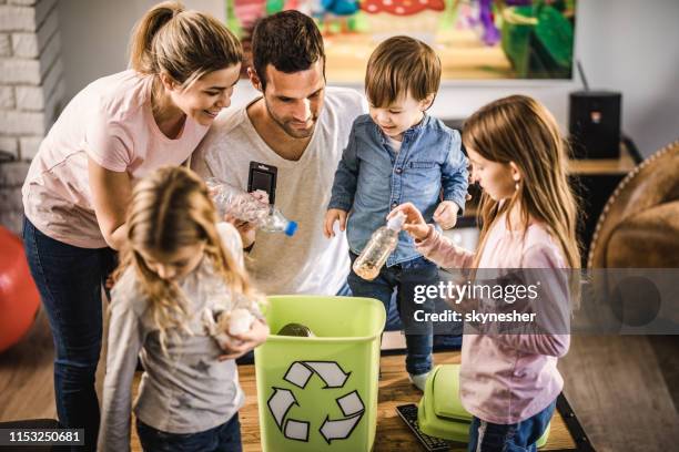 young family recycling garbage in a recycling bin at home. - lata de lixo imagens e fotografias de stock