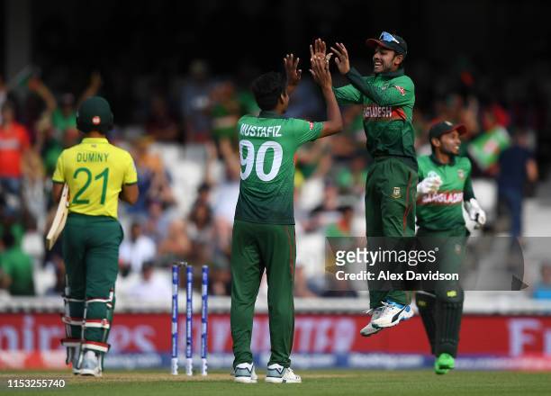 Mustafizur Rahman of Bangladesh celebrates the wicket of JP Duminy of South Africa with Mehedi Hasan of Bangladesh during the Group Stage match of...