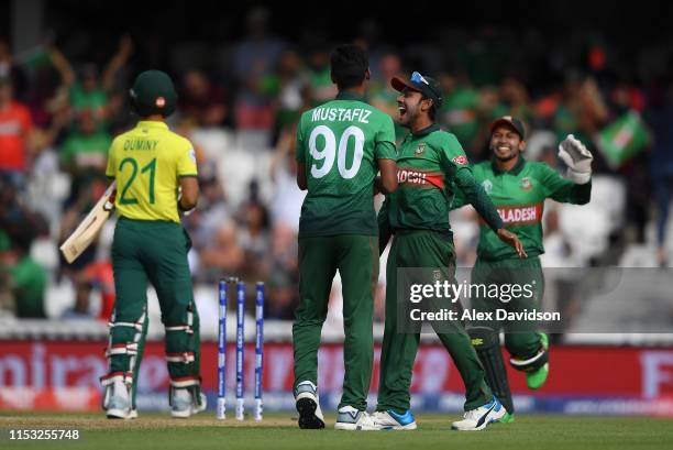 Mustafizur Rahman of Bangladesh celebrates the wicket of JP Duminy of South Africa with Mehedi Hasan of Bangladesh during the Group Stage match of...