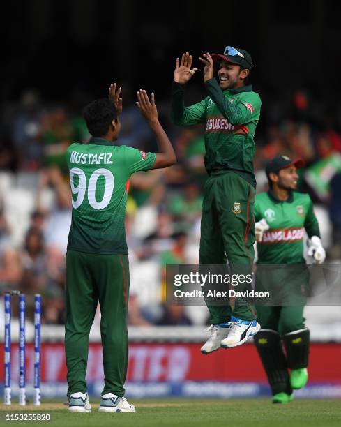 Mustafizur Rahman of Bangladesh celebrates the wicket of JP Duminy of South Africa with Mehedi Hasan of Bangladesh during the Group Stage match of...