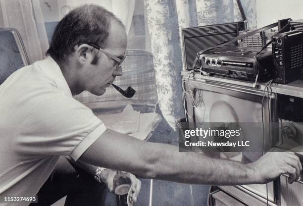 Hunter S. Thompson adjust the controls of a television set tuned in to the Watergate hearings during a stay at the Sherry-Netherland Hotel in New...