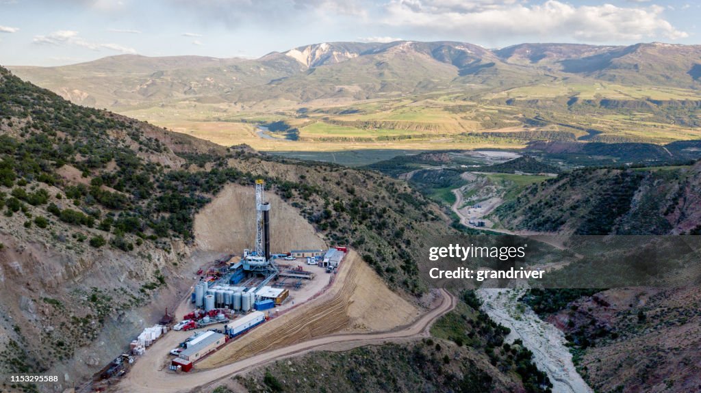 Une vue aérienne d’un gréement de forage de fracking sur le côté d’une montagne dans le Colorado à la fin du printemps