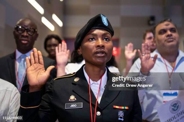 Army National Guard Pfc. Shamsiyyah Jibo, originally from Nigeria, takes the Oath of Allegiance as she becomes a new U.S. Citizen during a...